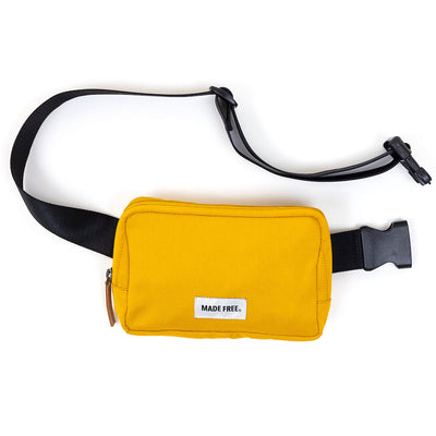 mustard yellow durable weather-resistant recycled polyester and seatbelt material adjustable strap hip pack, belt bag, fanny pack. Plenty of pockets and features to meet your minimalist needs for phone, keys, wallet and other items on the go. Includes a secure backside pocket. Leather zipper pulls Weather resistance polyester Seatbelt material adjustable strap Inside mesh pocket Black and white cotton striped lining  Secure backside pocket